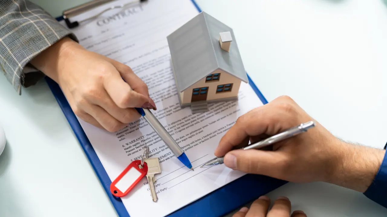 Signature d’un contrat de prêt Action Logement avec maquette de maison et clés, illustrant le dossier, les taux et les montants du prêt Action Logement en 2026.