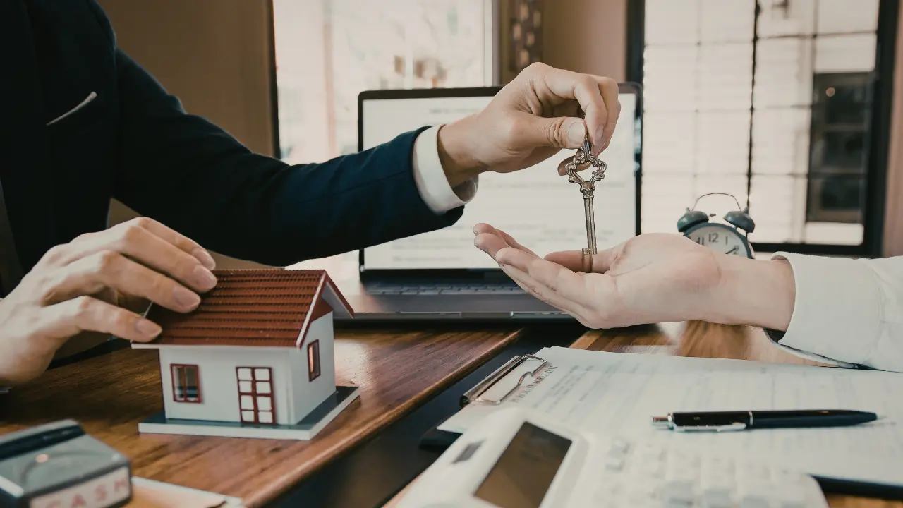 Courtier CAFPI remettant les clés d’un logement lors d’un rendez-vous crédit immobilier – avis, tarifs et services 2026